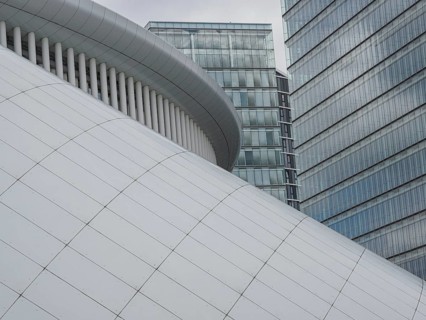 Architecturally modern building with white structure and neighbouring office towers in Luxembourg,
