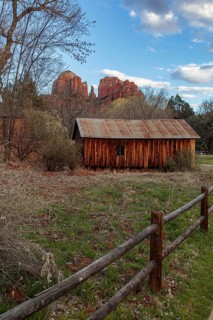 Cathedral Rock sandstone formations tower over a rustic barn at the Crescent Moon Picnic Site in