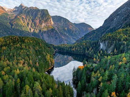 Aerial view, mountain peaks of the Oetztal Alps reflected in Lake Piburger See, in autumn, near