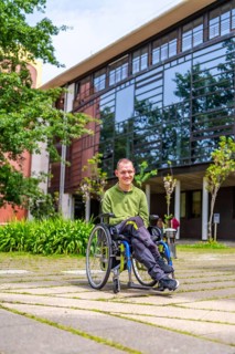 Vertical full length portrait of a proud adult caucasian man with disability in the university