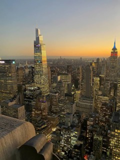 Cityscape during sunset with a multitude of illuminated skyscrapers, the skyline of new york with