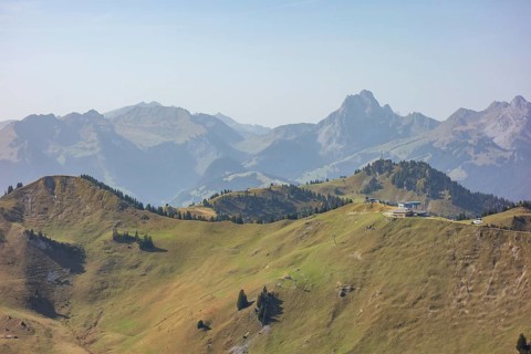 Tranquil mountain landscape with rolling hills and mountain peaks under a clear sky, mountain
