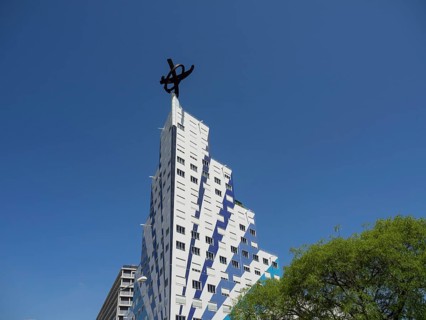 An ultra-modern building with an unusual design and strips of blue windows in bright sunshine,