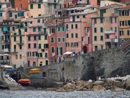 Colourful houses on the rocky coast with harbour and canoes on the water, Bari, Italy, Europe