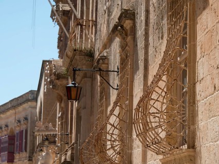 Historic street with stone facades and lanterns in a sunny town, the town of mdina on the island of