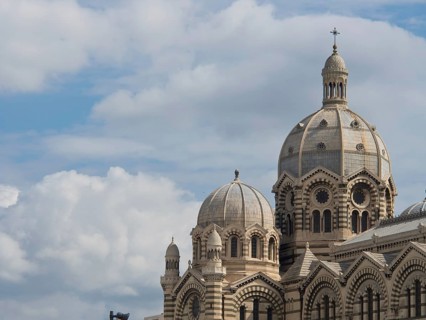 Close-up of a historic cathedral with large domes under a clear sky and some clouds, historic