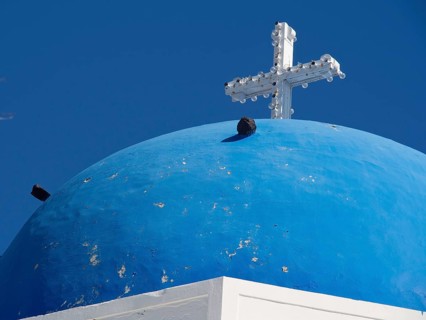 Blue dome with a white cross on a mediterranean church building, The volcanic island of Santorini