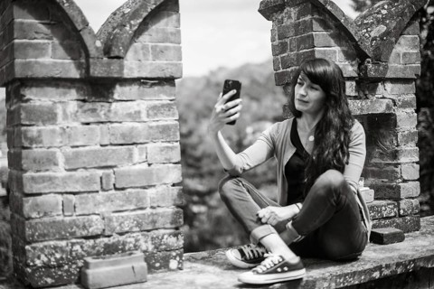 Young hispanic woman in casual clothing focused on conversation with smartphone in a peaceful