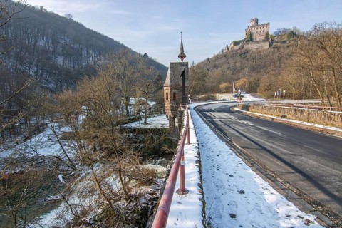 Beautiful landscape in winter with ice and snow. Waterfall of the river Elz near the castle