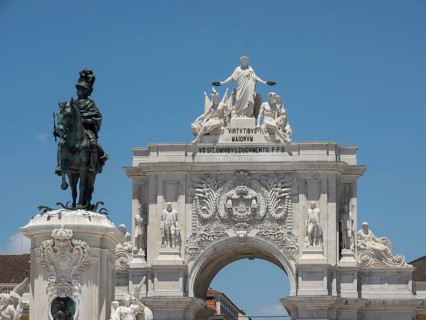 An impressive monument with an equestrian statue and an ornately decorated triumphal arch under a