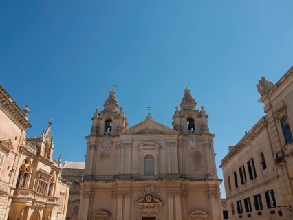 Historic buildings with a large church in the centre and two bell towers, the town of mdina on the