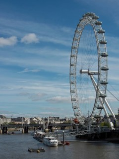 The London Eye next to the Thames under a slightly cloudy sky, London, England, United Kingdom,