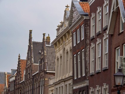 Historic buildings in an old town with ornate facades and tiled roofs, historic houses in Hoorn and