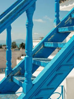 Close-up of a blue staircase with a view of the sea and white buildings, Tunis in Africa with ruins