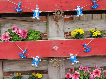Wooden fence with floral decorations and decorative bear figures, Baltrum Germany