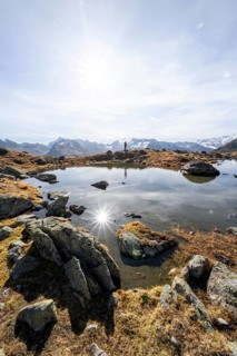 Mountaineers at a small lake on the high plateau of the Gurgler Seenplatte, glaciated mountain