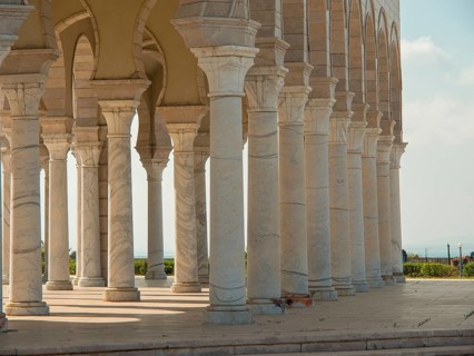 Row of stone columns of an arcaded structure, sky and landscape in the background, Tunis in Africa
