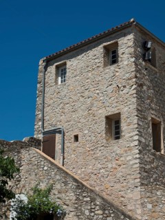 A three-storey stone house with small windows under a clear blue sky, Provence, le Castellet,