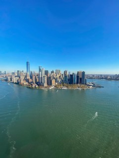 City view of an island with skyscrapers and water under a blue sky, the skyline of new york with