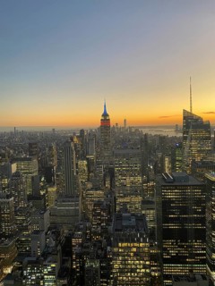 Cityscape at dusk with illuminated skyscrapers and the Empire State Building in the centre, the