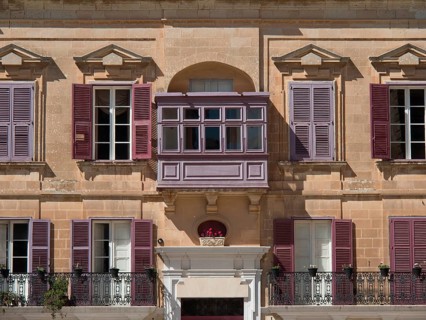 Building facade with purple shutters and small balconies, the town of mdina on the island of malta