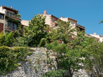 Several Mediterranean houses, surrounded by lush vegetation, under a clear blue sky, Provence, le