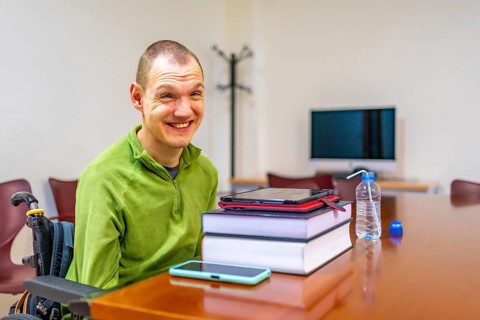 Man with disability sitting in wheelchair in the study room of the university