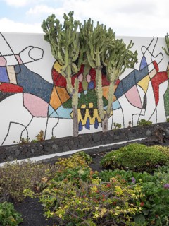Colourful mosaic artwork on a wall with a cactus in the foreground, Lanzarote, Spain, Europe