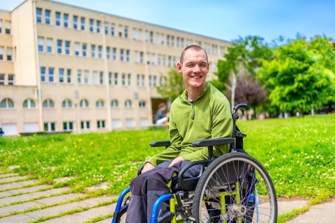 Man with disability sitting in an electric wheelchair in the university campus