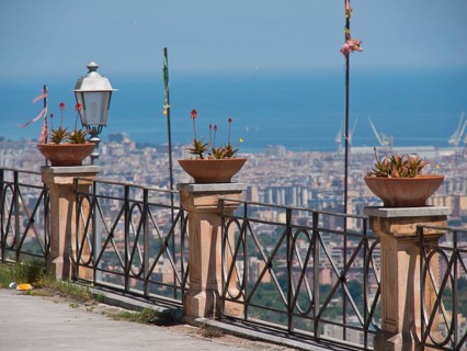 Urban view of the sea with pots and plants on the railing, clear sky and summer feeling, palermo in