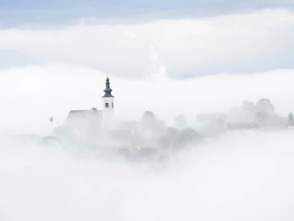 Church rises out of the morning mist, Frauenberg pilgrimage church, near Leibnitz, Styria, Austria,