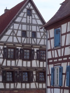 Historic half-timbered house with blue shutters and rustic architectural details, historic