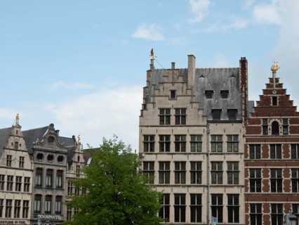 Historic buildings with different gables and a tree in front under a blue sky, Historic buildings,