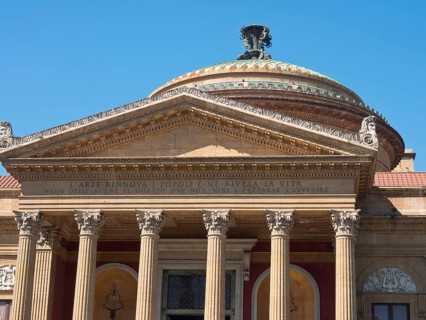 Historic building with magnificent dome and columns in front of a cloudless blue sky, palermo in
