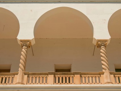 White and beige arcaded structures with columns and balconies, Tunis in Africa with ruins from