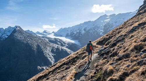 Mountaineers on a hiking trail, hiking trail to Ramolhaus, behind glaciated mountain peaks and