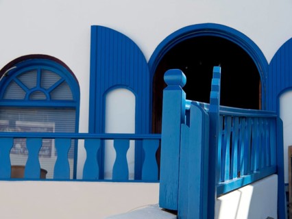 A blue and white building with traditional Greek design elements, The volcanic island of Santorini