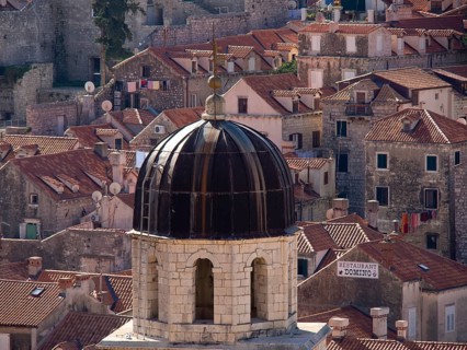 Domed roof of a church and surrounding old buildings with red roof tiles, the old town of Dubrovnik
