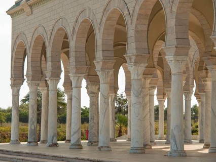 The exterior of a building with marble columns and arches in bright light, Tunis in Africa with