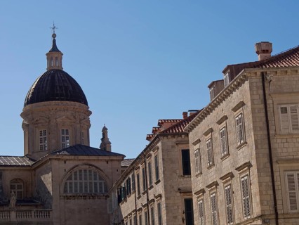Large church with dome and neighbouring buildings against the blue sky, the old town of Dubrovnik