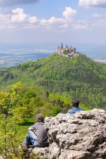 Hikers looking at Hohenzollern Castle near Hechingen, cloudy sky, Zollernalbkreis, Swabian Alb,