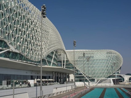 Building with modern grid structure, large windows and racetrack under blue sky, Abu Dhabi, United