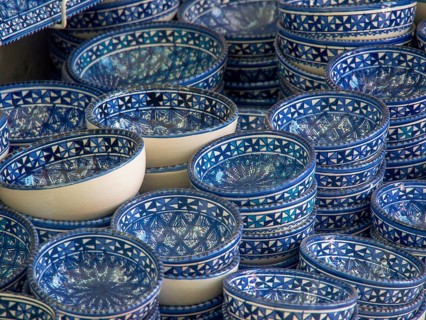 A collection of blue ceramic bowls with traditional patterns stacked on a market stall, Tunis in