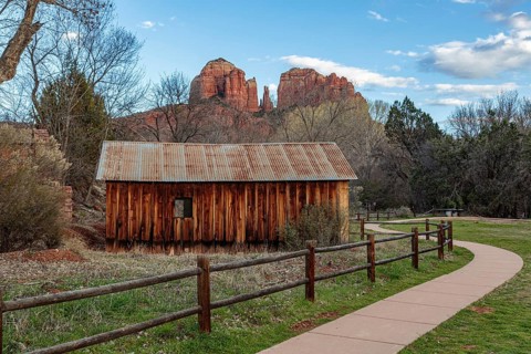 Cathedral Rock sandstone formations tower over a rustic barn at the Crescent Moon Picnic Site in