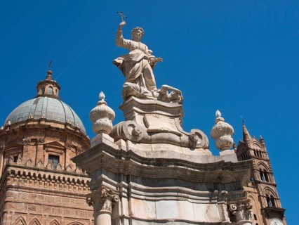 Baroque church structure with dome and stone statue holding a cross, palermo in sicily with an
