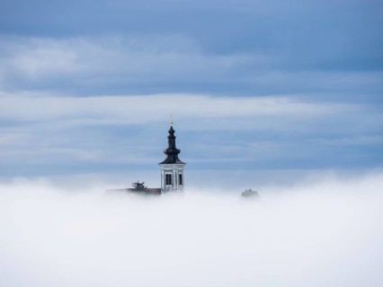 Church tower rises out of the morning mist, Frauenberg pilgrimage church, near Leibnitz, Styria,