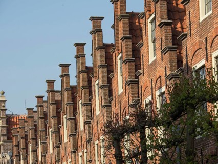 Detail of a historic brick building with distinctive gables and windows in sunny weather, Haarlem,