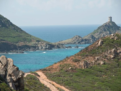 Path leading along a rocky coastline with turquoise sea and an old fortress, Corsica, Ajaccio,