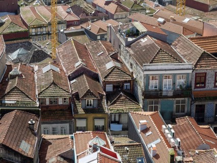 Tightly packed houses with red tiled roofs and windows that characterise the city panorama, old