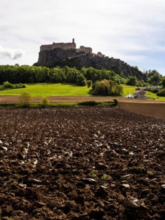 Clods of earth in farmland, Riegersburg Castle in the background, near Riegersburg, Styria,